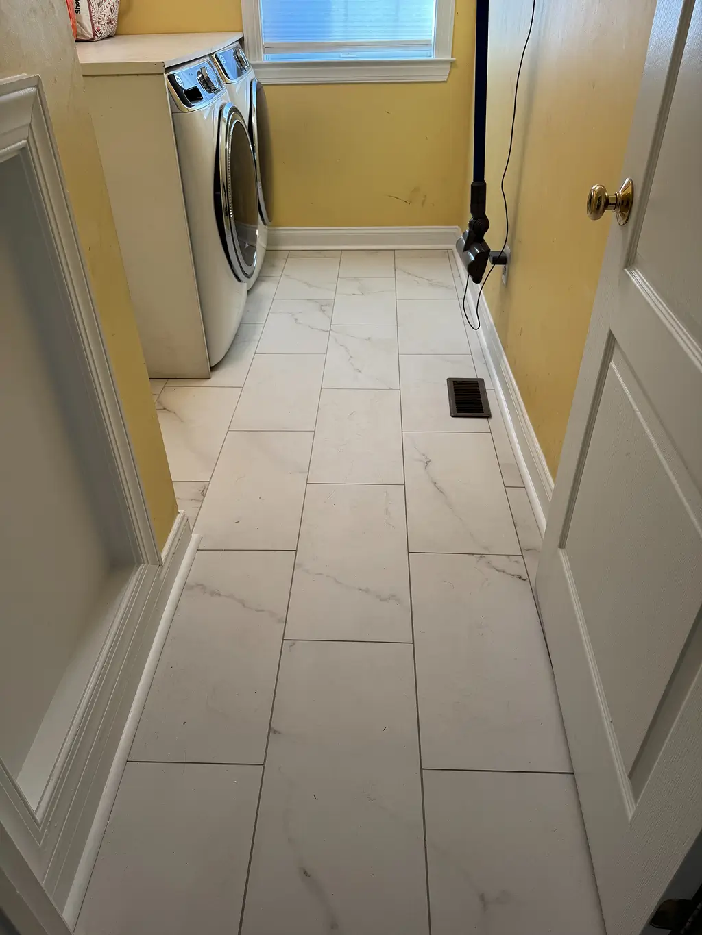 Renovated laundry room with new tile flooring after home remodel in Northern Virginia